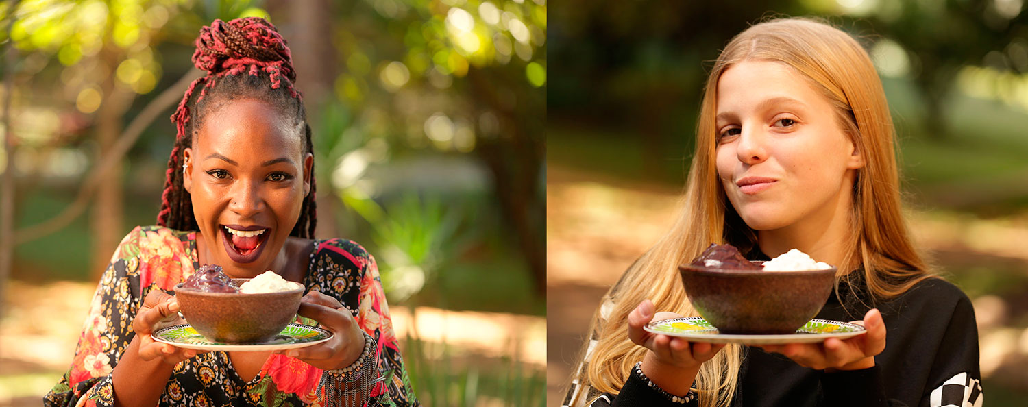 Moça Negra e uma Moça Loira ambas segurando uma tigela de açaí.